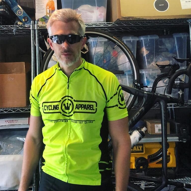 Nate Clark wearing cycling gear standing in front of his bike